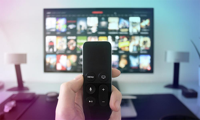 Person holding apple tv remote for connected tv